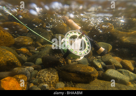 Vista subacquea di una canna da mosca e la bobina in rapido movimento di acqua Montana Creek, Alaska Foto Stock