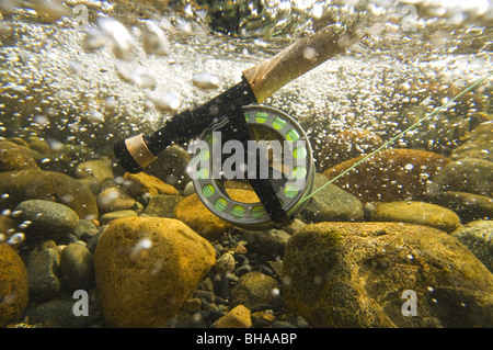 Vista subacquea di una canna da mosca e la bobina in rapido movimento di acqua Montana Creek, Alaska Foto Stock