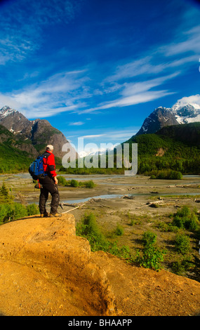 Escursionista sorge su uno sperone di roccia affacciato sul fiume Eagle, Chugach State Park, centromeridionale Alaska, estate Foto Stock