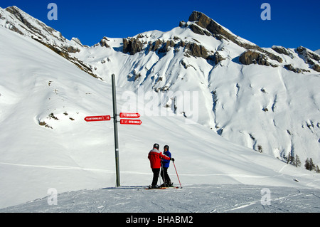 Due gli sciatori standing at un segno direzionale nell area sciistica Ovronnaz, Vallese, Svizzera Foto Stock