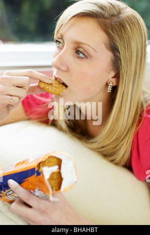 Teen ragazza di mangiare i biscotti Foto Stock