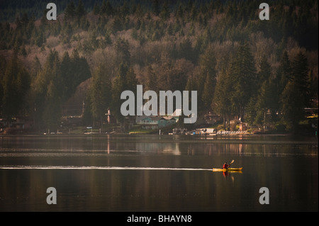 Un kayaker palette per la mattina presto la calma del lago Samish nella contea di Whatcom vicino a Bellingham, Washington, Stati Uniti d'America. Foto Stock