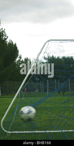 Il calcio di colpire il retro del net nel gioco del calcio Foto Stock