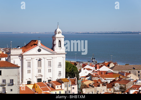 Quartiere di Alfama con Santo Estevao chiesa e il fiume Tago estuario visto da Miradouro de Santa Luzia. Lisbona, Portogallo. Foto Stock