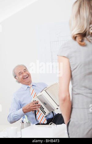 L'uomo la riproduzione di melodeon in un ufficio Foto Stock