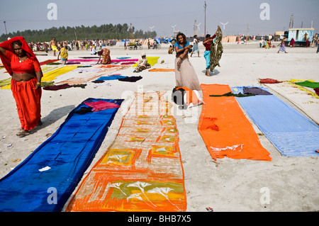 Essiccazione fino loro sari colorati sulla spiaggia di sabbia di Gangasagar. Foto Stock