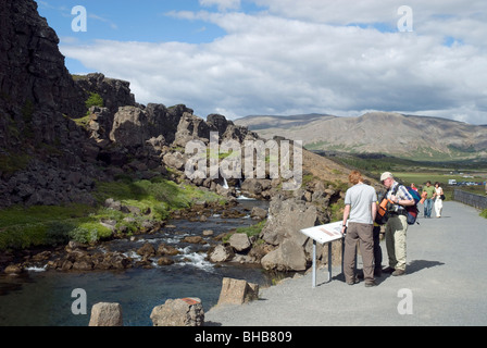 I turisti per la lettura di informazioni in Almannagja Gorge, Pingvellir, Golden Circle, Islanda Foto Stock