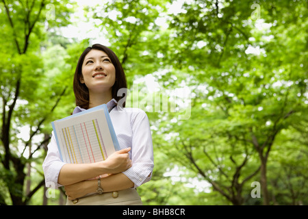 Giappone, nella prefettura di Osaka, imprenditrice guardando in alto, sorridente, basso angolo di visione Foto Stock