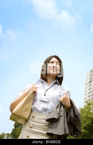 Giappone, nella prefettura di Osaka, imprenditrice guardando lontano, sorridente Foto Stock