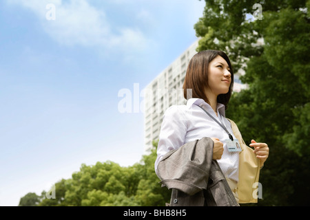 Giappone, nella prefettura di Osaka, imprenditrice guardando lontano, sorridente Foto Stock