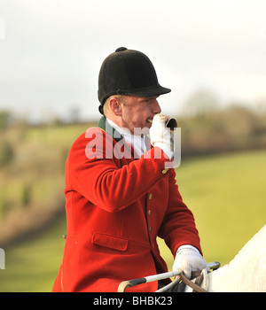 David Lewis, huntsman di lamerton foxhounds, soffiando il suo corno da caccia Foto Stock