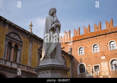 Verona, Veneto, Italia. Statua del poeta Dante Alighieri in Piazza dei Signori, la facciata del Palazzo del Governo al di là. Foto Stock