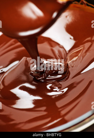 Fuso cioccolato scuro e ricco gocciolamenti dal cucchiaio Foto Stock