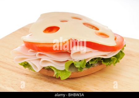 Aprire la Turchia il formaggio svizzero sandwich con lattuga e pomodoro su un bagel su un tagliere. Sfondo bianco. Foto Stock