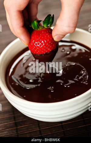 Lato di immersione di fragole fresche nel cioccolato fuso Foto Stock