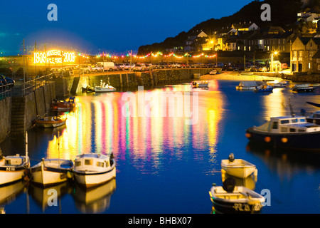 Il calare della notte su barche ondeggiando sulla marea nel porto nel vecchio villaggio di pescatori di Mousehole, Cornwall Foto Stock