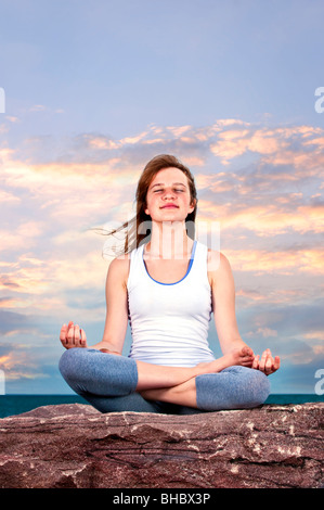 Ritratto di giovane ragazza adolescente a praticare yoga al tramonto Foto Stock