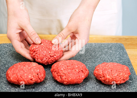 Lo Chef rendendo hamburger polpette in cucina con carne macinata di manzo Foto Stock