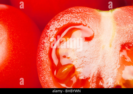 Mature succosi pomodori rossi intero e dimezzato da vicino Foto Stock