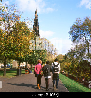 Gli studenti a piedi lungo una traiettoria verso il Monumento di Scott giardini di Princes Street di Edimburgo, Scozia, Regno Unito Foto Stock