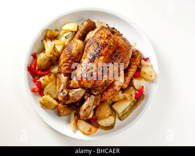 Pollo arrosto servita con patate su un tavolo bianco Foto Stock