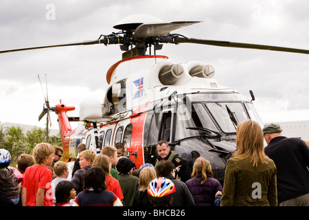 Le persone si radunano attorno ad un elicottero da la Icelandic Coast Guard, Vogar in Vatnsleysustrond, Islanda. Foto Stock