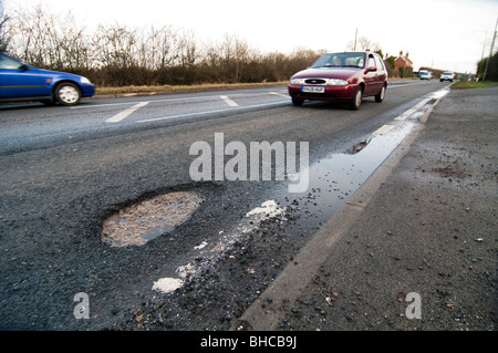 Vetture evitare grandi profonda buca nella strada Foto Stock