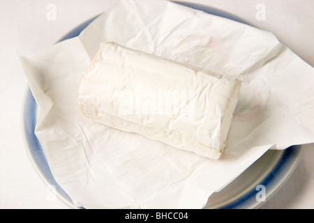 Francese di formaggio di capra su carta e lastra blu Foto Stock