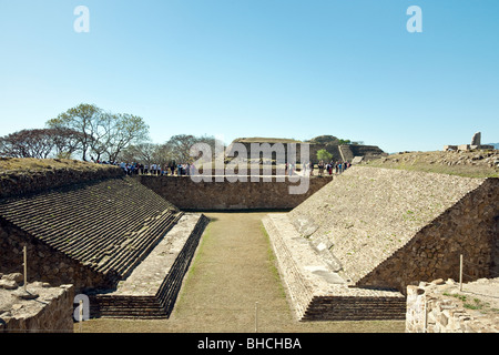 Scuola messicana gruppo e un gruppo di turisti indagine la palla della antica zapoteco città di Monte Alban Messico Oaxaca Foto Stock