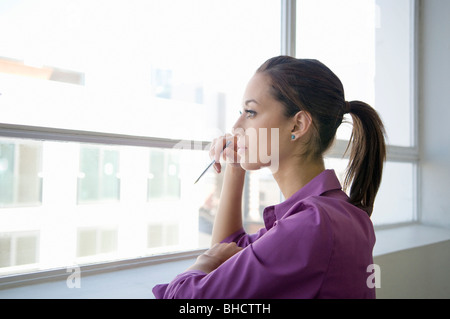 Business donna guardando fuori della finestra Foto Stock