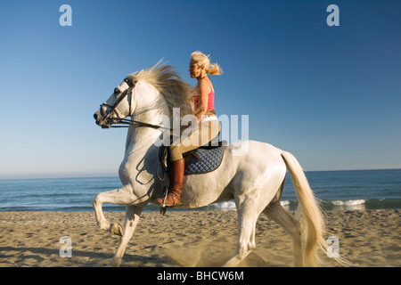 La donna a cavallo sulla spiaggia Foto Stock