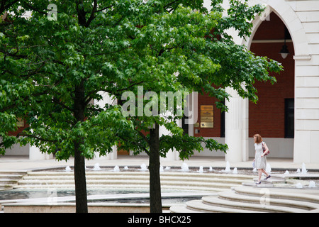 Una donna di passeggiare attraverso le fontane in piazza centrale, Brindleyplace, Birmingham, West Midlands. Foto Stock