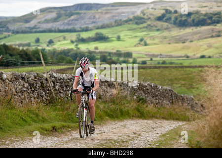 Ciclista corse in salita durante le Tre Cime di Lavaredo Cyclo-Cross nello Yorkshire, Regno Unito Foto Stock