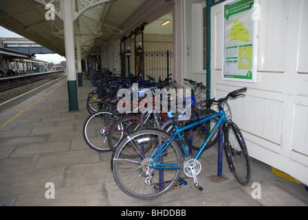 Biciclette concatenati a un rack di ciclo sulla piattaforma a Chippenham Stazione ferroviaria Wiltshire, Regno Unito Foto Stock