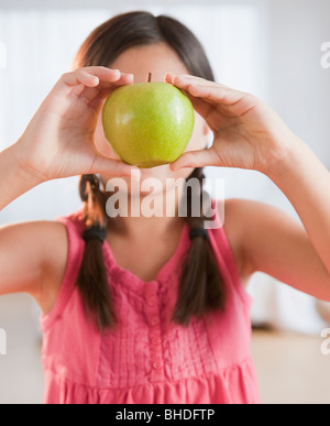 Razza mista ragazza con mela verde Foto Stock