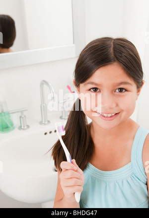 Razza mista ragazza con spazzolino da denti Foto Stock