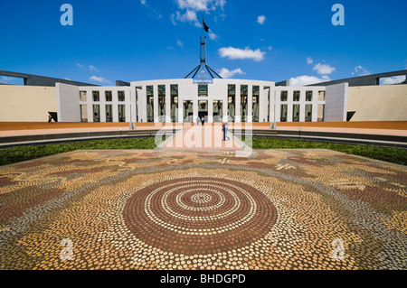 Parliament House Aboriginal Tiled Design Canberra Australia // CANBERRA, Australia - il fronte del Parlamento, caratterizzato da un design piastrellato aborigeno sul terreno. Il Parlamento è il luogo di incontro del Parlamento australiano. Si trova a Canberra, la capitale dell'Australia. Fu inaugurato il 9 maggio 1988 dalla regina Elisabetta II d'Australia. Il costo di costruzione è stato di oltre 1,1 miliardi di dollari. Al momento della sua costruzione era l'edificio più costoso dell'emisfero meridionale. Prima del 1988, il Parlamento australiano si riunì nella camera provvisoria del Parlamento, che ora è k Foto Stock