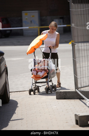 Madre spingendo una carrozzina, Poznan, Polonia Foto Stock