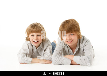 Due giovani ragazzi giacente su stomaco in Studio Foto Stock