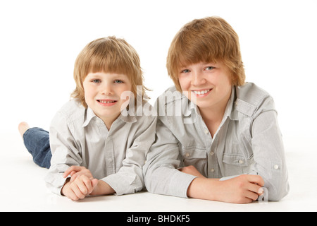 Due giovani ragazzi giacente su stomaco in Studio Foto Stock