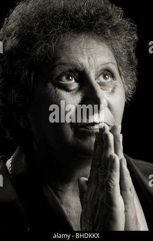 Dai toni monocromatici ritratto di una donna senior isolato su nero Foto Stock