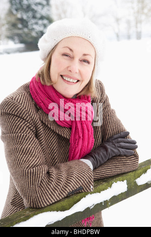 Senior donna in piedi fuori nel paesaggio innevato Foto Stock