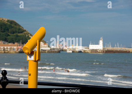 Cannocchiale giallo sul lungomare di South Bay che guarda verso il porto e il faro. Scarborough, Regno Unito Foto Stock