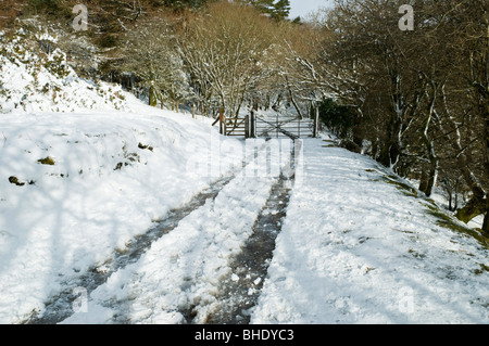 Veicolo le vie che portano al gateway in disuso la linea ferroviaria ricoperta di neve Dartmoor Devon Regno Unito Foto Stock