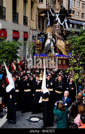 Il grande trono con la scena Paso è portato in una strada stretta durante la celebrazione della settimana Santa a Malaga, Spagna. Foto Stock