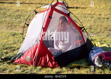 Donna di svegliarvi in tenda. Foto Stock