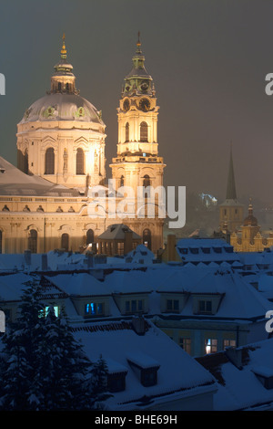 Praga - vista dei tetti innevati e st. nicolaus chiesa in inverno Foto Stock