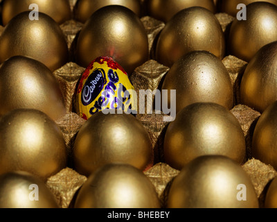 Un Cadbury crema di uovo in tra uova d'oro Foto Stock