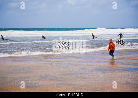 Istruttore Sufing spostando le bandiere di sicurezza sulla spiaggia di Fanore, County Clare, Irlanda. Foto Stock