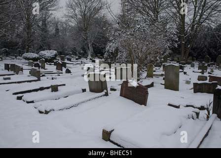 St Leonards cimitero con lapidi coperte di neve, Heston West London, Regno Unito Foto Stock